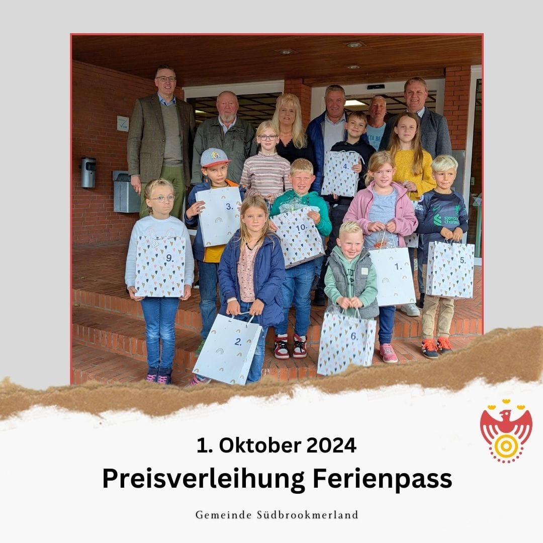 Preisverleihung Ferienpass. Einige Erwachsene und Kinder lächeln in die Kamera. Die Kinder halten jeweils eine Tüte.