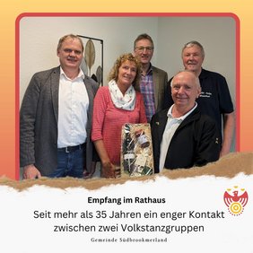 Empfang im Rathaus. Mehrere Personen lächeln in die Kamera