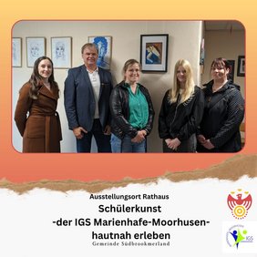 Ausstellungsort Rathaus. Mehrere Personen lächeln in die Kamera. Im Hintergrund hängen einige Kunstwerke.